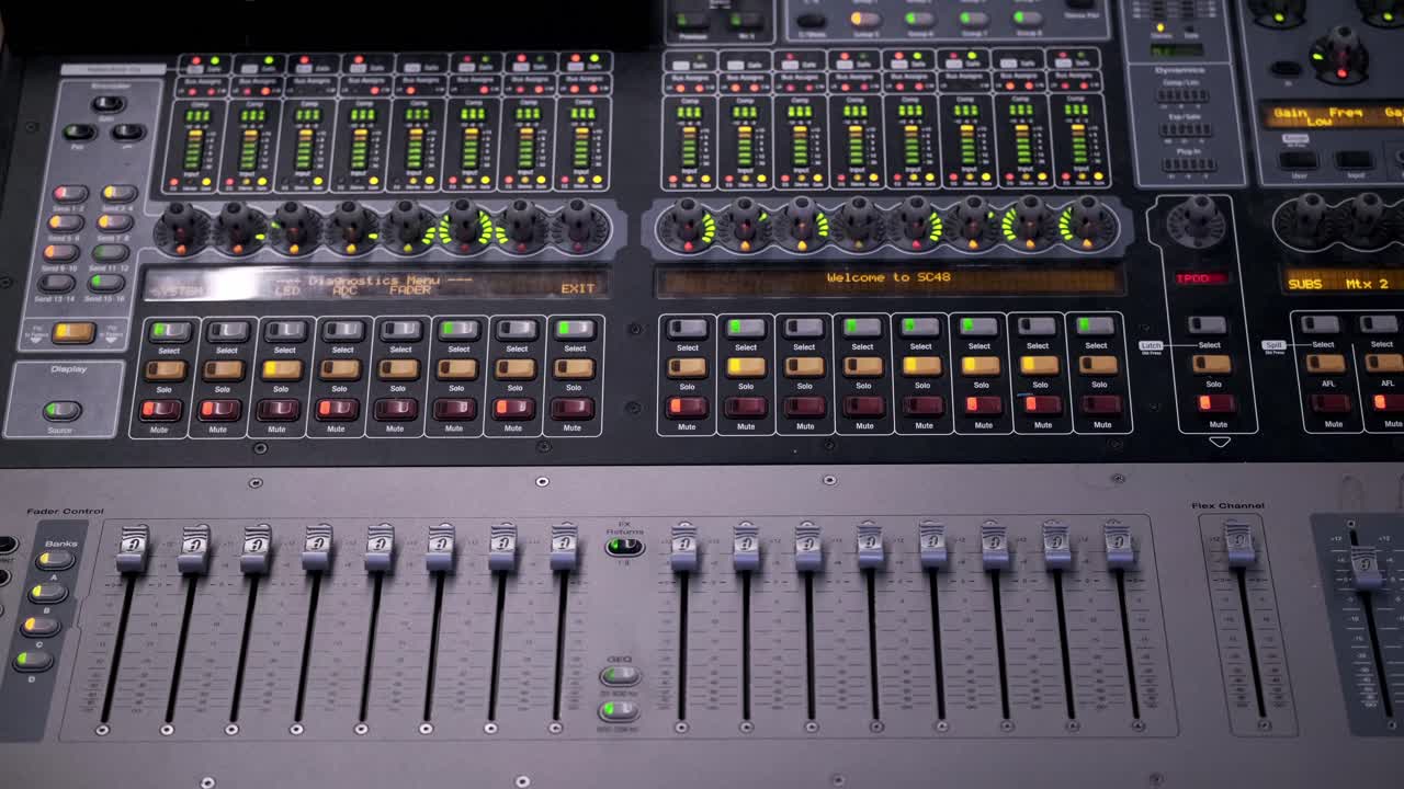 Colorful dancing indicator lights and levers on a mixing board