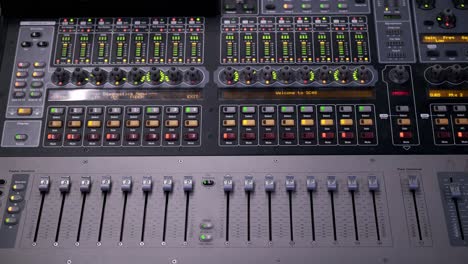 colorful dancing indicator lights and levers on a mixing board