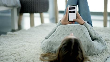 woman relaxing on carpet, using smartphone