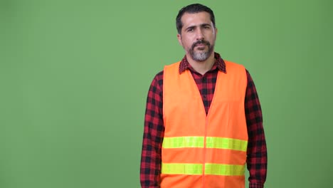 handsome persian bearded man construction worker showing something