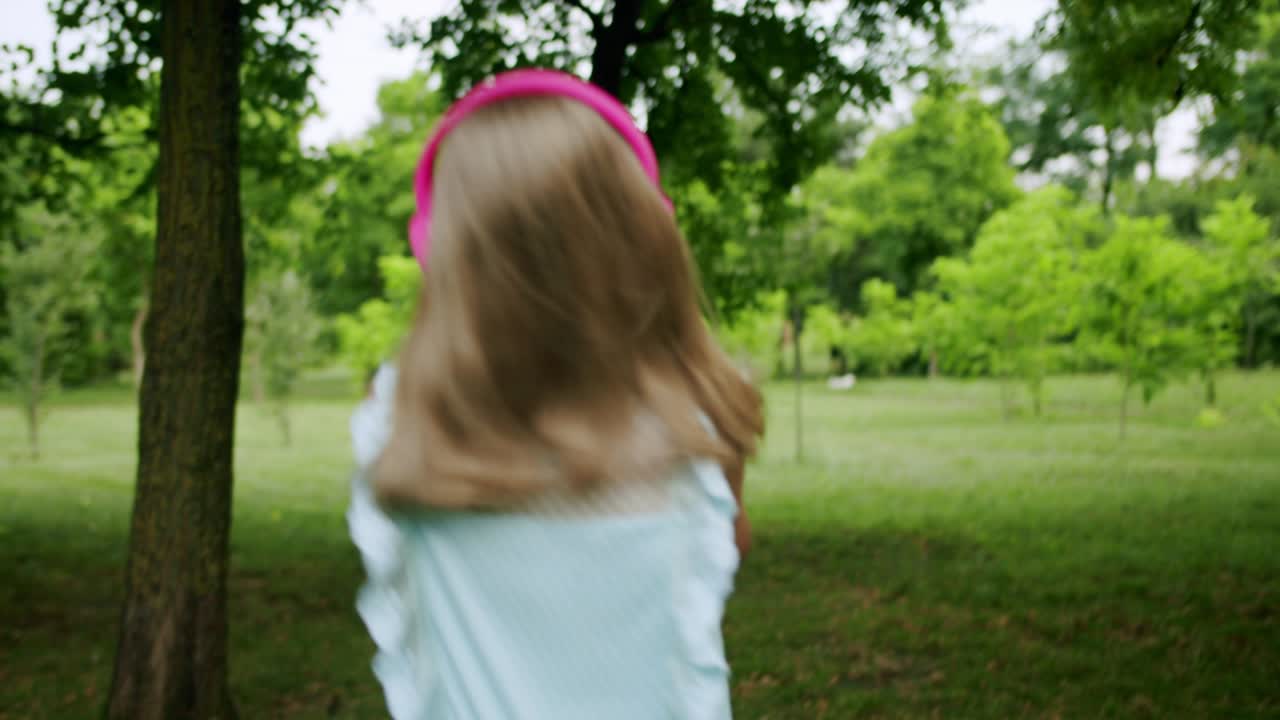 niña feliz con auriculares bailando y saltando mientras escucha la música