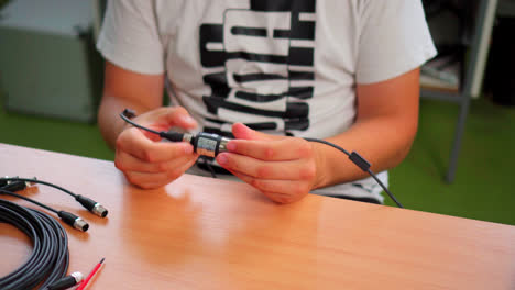 male student disconnecting laser distance measuring tool in a vocational school