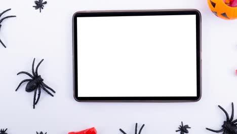 Animation-of-spiders-and-tablet-on-white-background