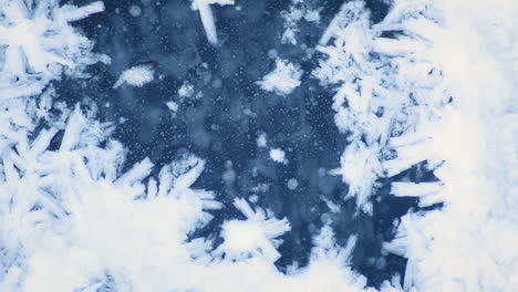 macro shot of blue ice partly covered by white snow crystals