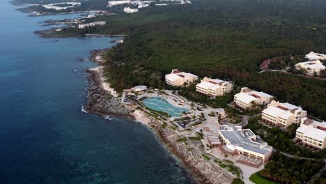 Beautiful-spinning-aerial-drone-view-of-the-tropical-coastline-of-playa-del-carmen-with-large-vacation-resorts-in-Riviera-Maya,-Mexico