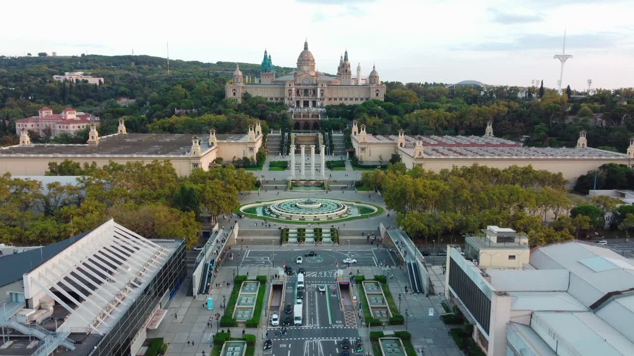 vista aérea de montjuic en barcelona, con turistas caminando por un puente peatonal, la fuente mágica, el palacio nacional y otros cinco palacios