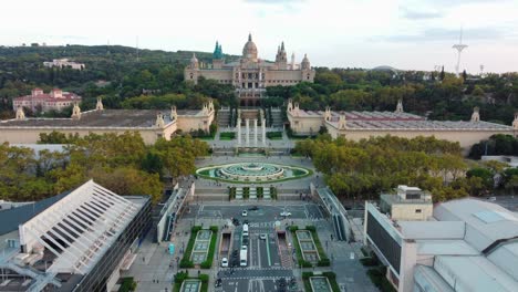 aerial view of montjuic in barcelona, with tourists walking across an escalator footbridge, the magic fountain, the national palace, and five other palaces