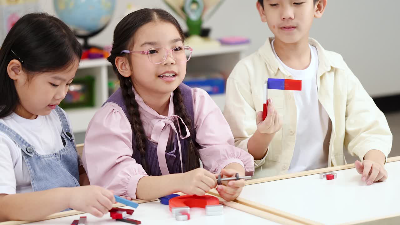 3人の小学生が、実践的なSTEM授業のアクティビティでカラフルな磁石を使って磁力を探求している。