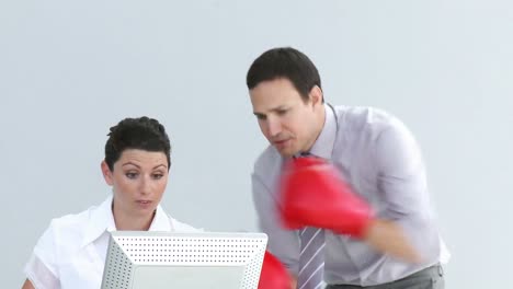 Furious-manager-wearing-boxing-gloves-talking-to-his-colleague