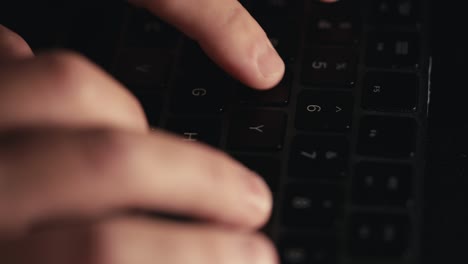 close up macro shot of fingers typing on a black computer keyboard