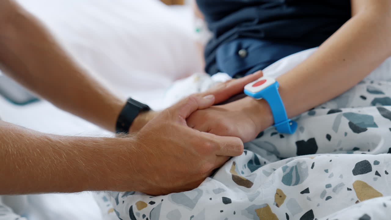 Female hand wearing a button to call medical personnel. Emergency call device in the maternity hospital. Close up.