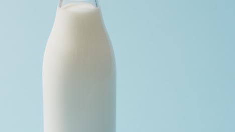 video of glass bottle of milk on blue background