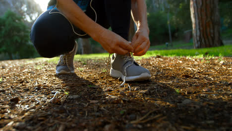 Senior-woman-tying-shoe-laces-in-the-park-4k