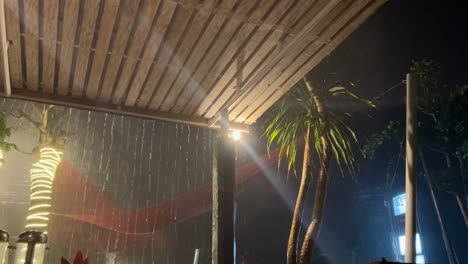 night tropical storm in bali, wooden porch view with thunderstorm and bolts of lightning