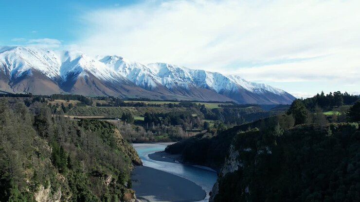 Ripresa aerea inversa sopra la splendida Gola del fiume Rakaia - prima mattina, metà inverno, neve fresca sul Monte Hutt.