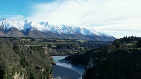 aerial reverse above beautiful rakaia river gorge - early morning, mid-winter, fresh snow on mount hutt