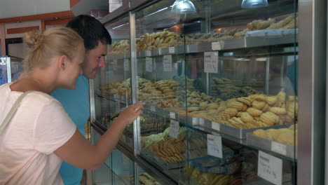 couple choosing tasty cookies in the grocery