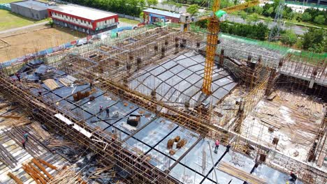 Aerial-drone-reverse-view-revealing-a-huge-construction-site-with-workers