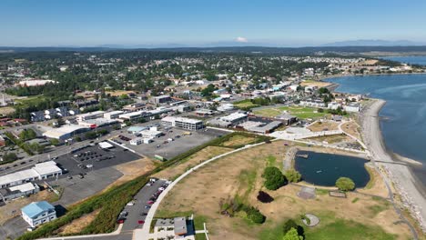 Aerial-shot-of-Windjammer-Park-and-old-downtown-in-Oak-Harbor,-WA-with-Mount-Baker-on-the-horizon