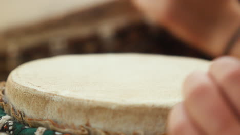 close-up of a white woman's hands playing a bongo in slow motion, bathed in the soft light of the late afternoon