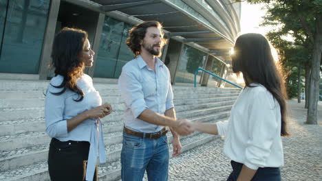 hr manager and job applicant shaking hands at end of successful interview with business assistant standing nearby