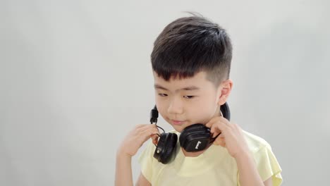 asian chinese kid listening to music with headphone and shake his head