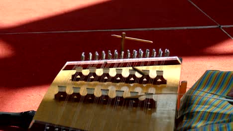 una joven asiática en tailandia tela tradicional toca una canción en un dulcimer martillado, instrumento musical de madera dulcimer tailandés