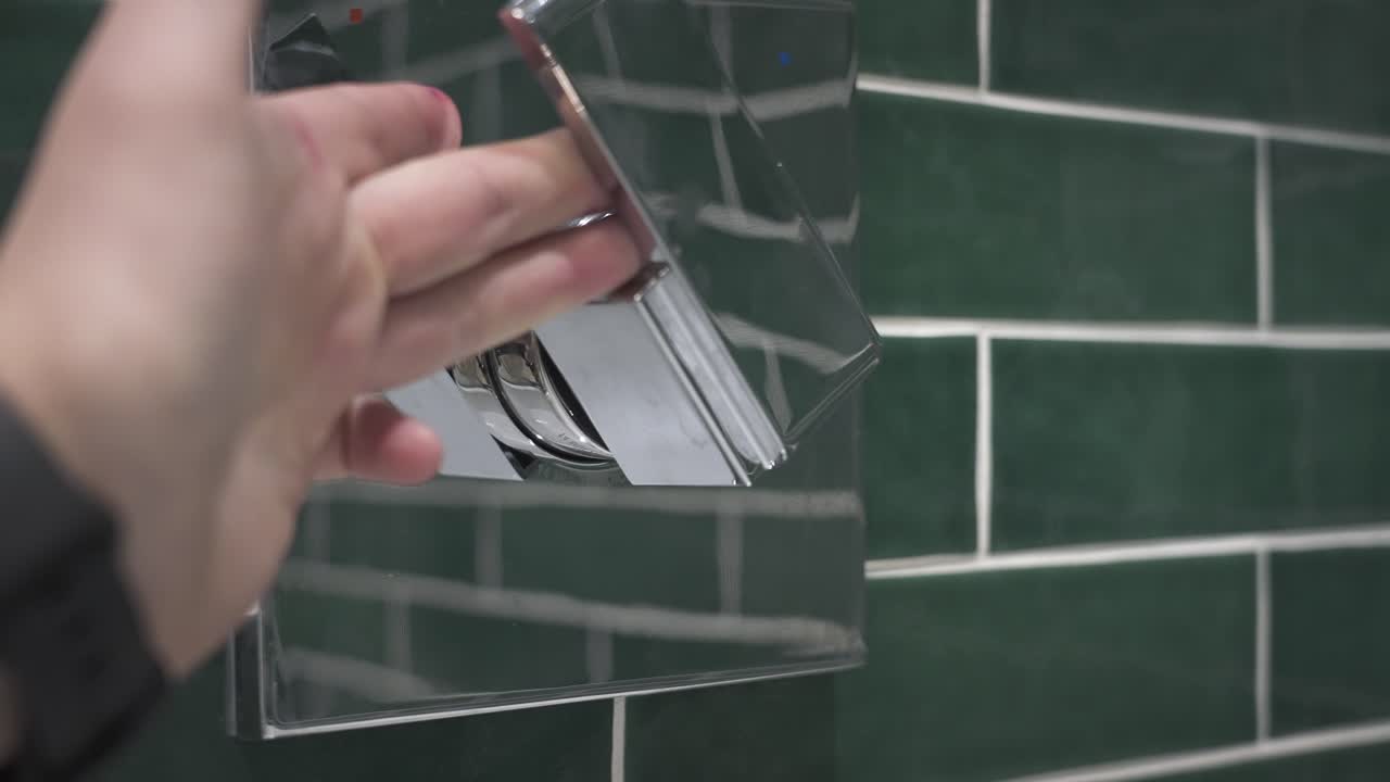 un hombre alcanza el cuadro y enciende el grifo de la bañera en cámara lenta