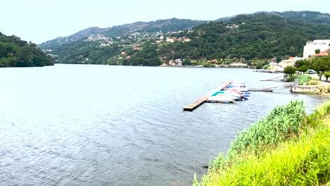 small boats moored along a quaint river dock on a cloudy day in baião, portugal