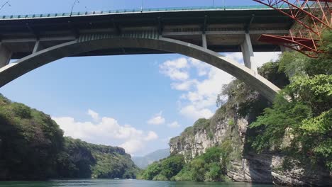 barco navegando por el río grijalva pasando un puente, chiapas, méxico.