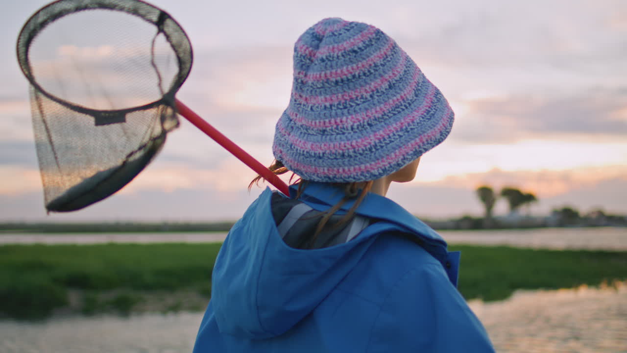 해가 지면 강변에서 휴식을 취하는 휴양 소녀. 여행하는 암 나비