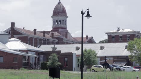 rustic old mental institution with cars parked