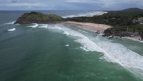 Surfistas-Montando-Olas-De-Mar-Agitadas-En-La-Playa-De-Cabarita-Adyacente-Al-Promontorio-De-Norries-En-Nueva-Gales-Del-Sur,-Australia