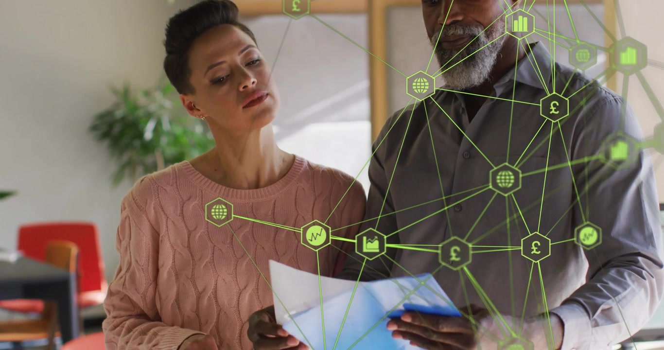 Colleagues flipping pages and pointing as network graphic shifting over folders with finance charts