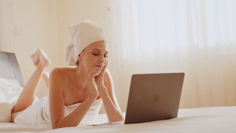 woman relaxing in bed with laptop