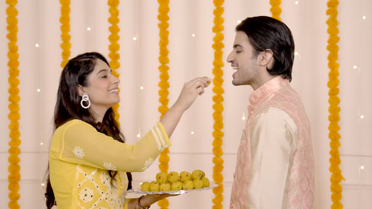 Adorabile coppia indiana che mangia dolci a Diwali
