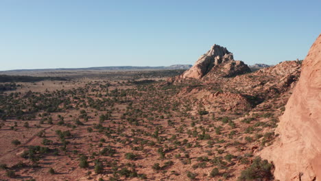 Drone-flies-over-desert-landscape-with-large-rock-formation