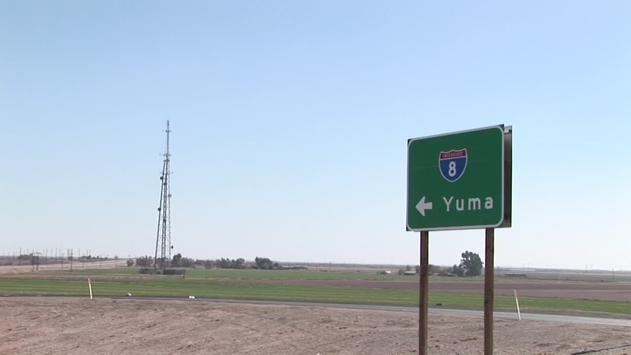 트럭이 유마를 가리키는 도로 표지판을 지나갑니다.