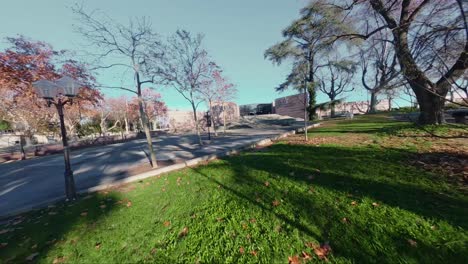 fpv drone flight from the park to the corum entrance in montpellier city, followed by aerial view of the building