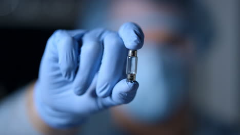 blurred silhouette of doctor presenting vaccine for infection disease indoors.