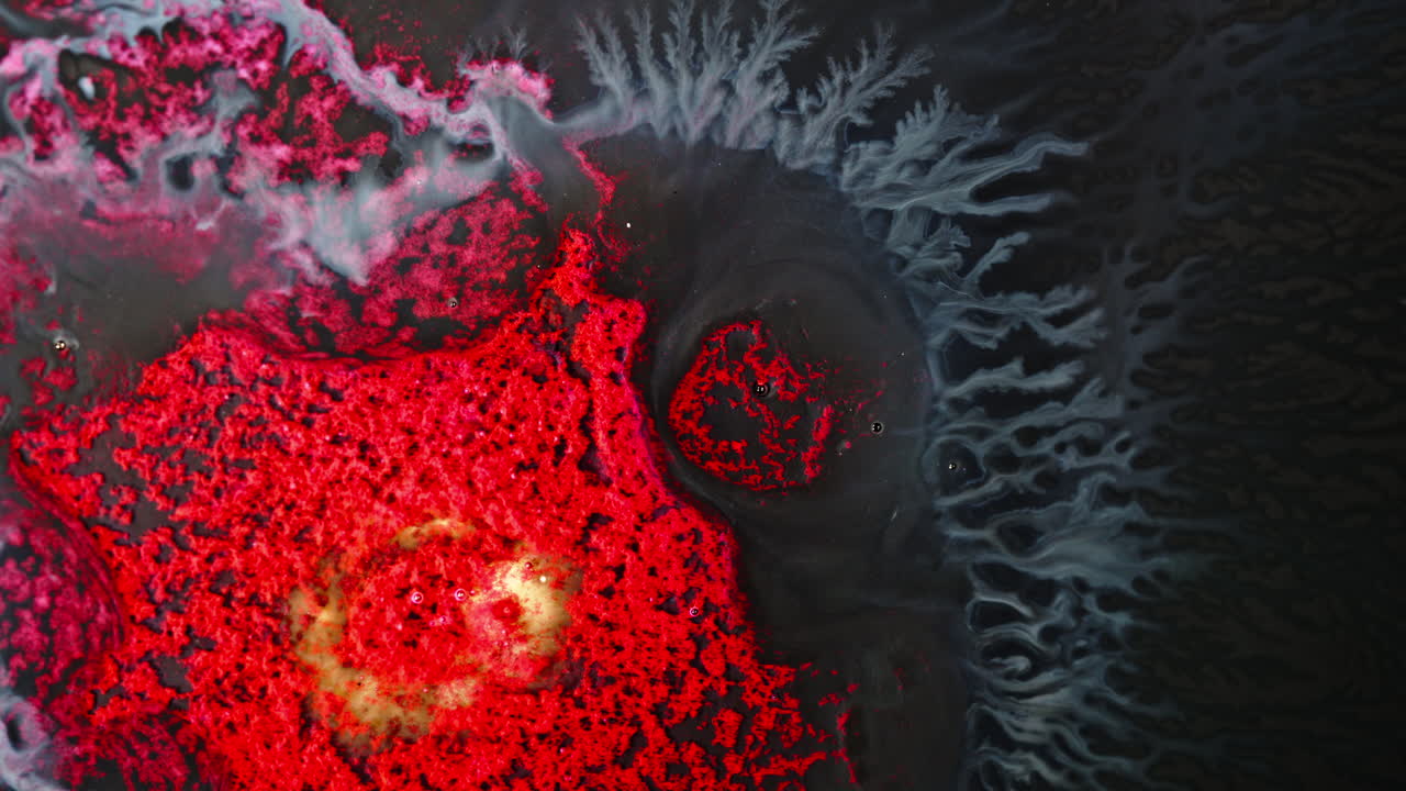 Abstract ink patterns mixing in water, vibrant red and blue hues creating dynamic swirls