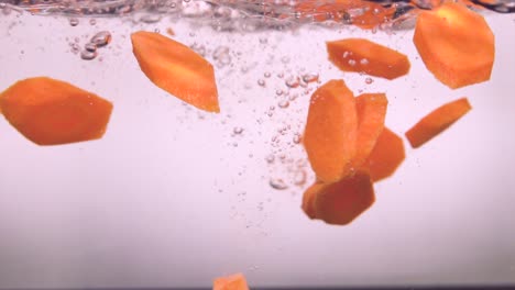 Sorted-carrots-slices-falling-into-water