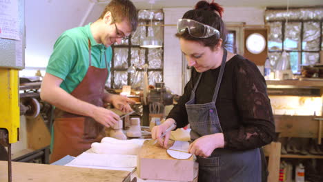 workers in bespoke shoemakers measuring template for last