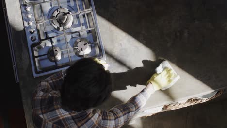 happy caucasian man cleaning worktop in kitchen, slow motion