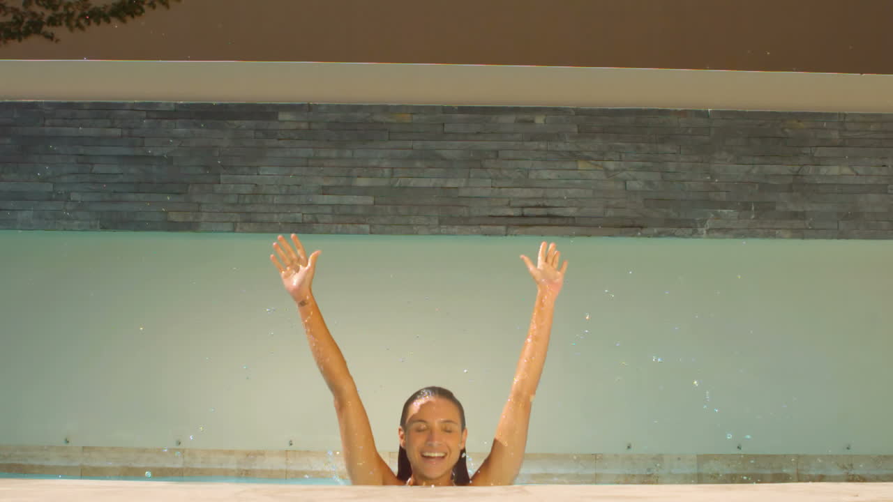 매력적인 여성이 점프하고 손을 들어 올립니다.