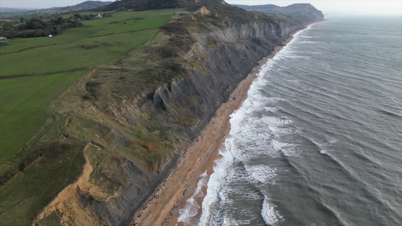 inclinación aérea hacia arriba que revela increíbles acantilados a lo largo de la playa de charmouth, cerca de dorset, reino unido