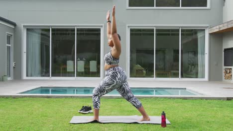 Happy-african-american-plus-size-woman-practicing-yoga,-standing-stretching-in-garden