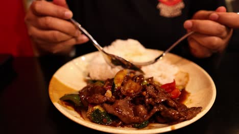 person enjoying stir-fried sweet and sour pork