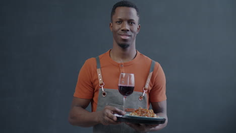 smiling waiter serving food and wine