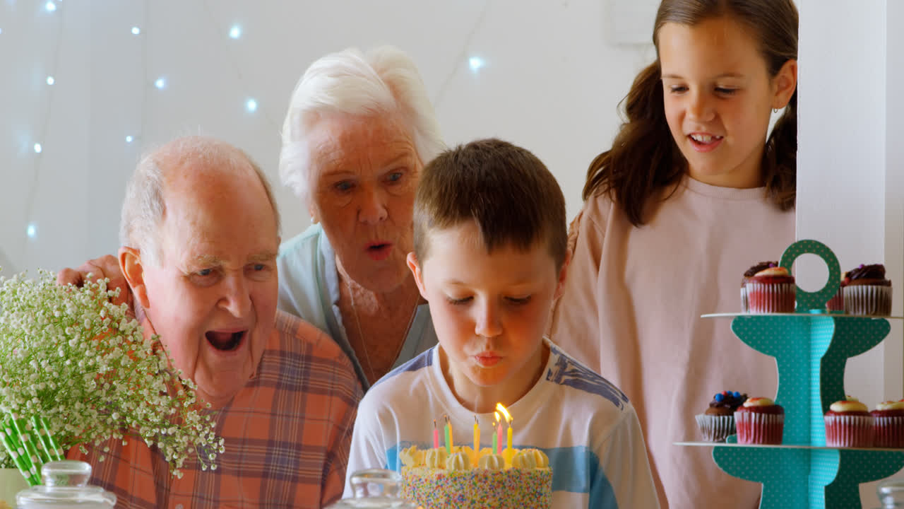 vista frontale di una famiglia caucasica multigenerazionale che celebra il compleanno del nipote in un comodo